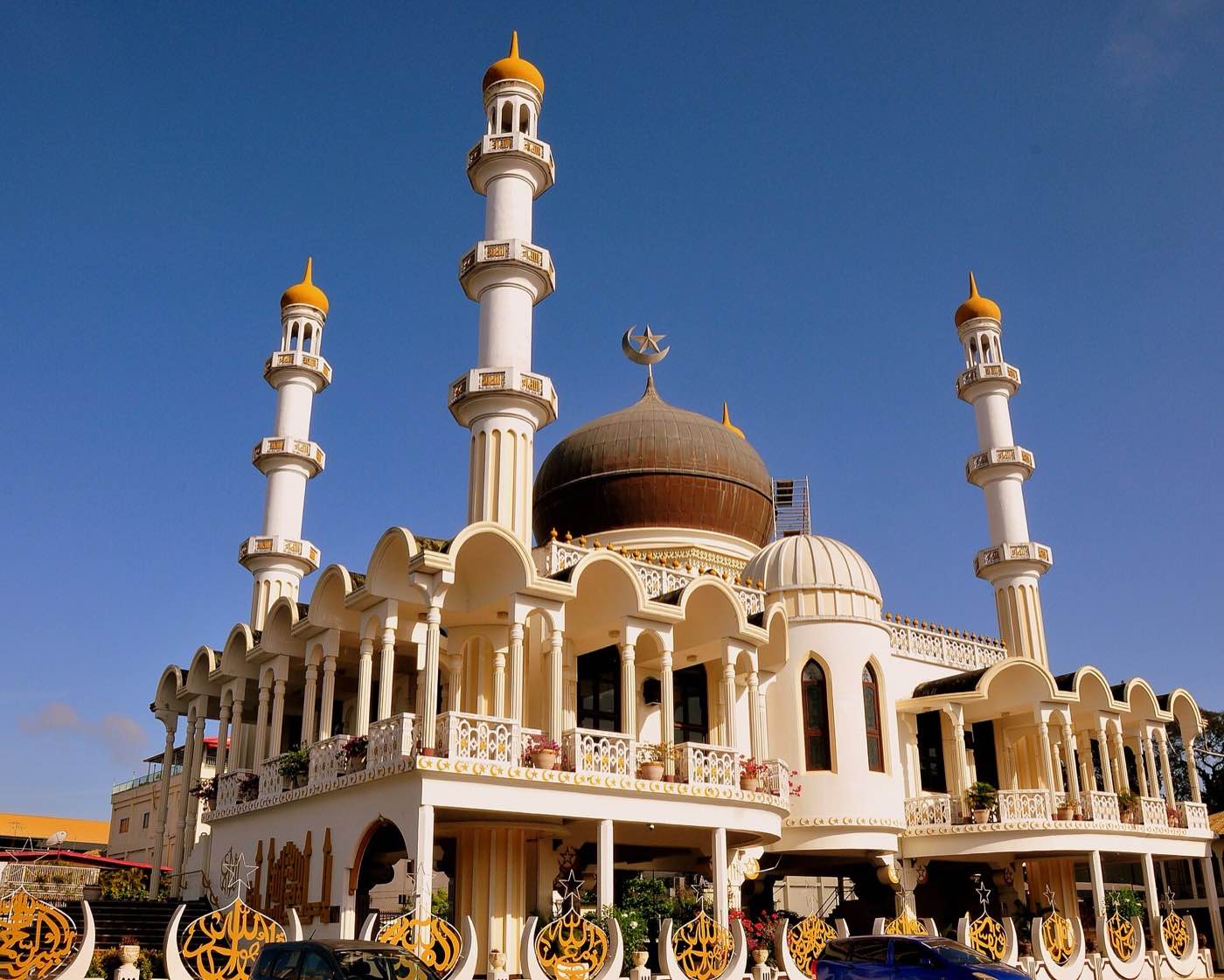 The white Keizerstraat mosque in Paramaribo with its four minarets and dark central dome.