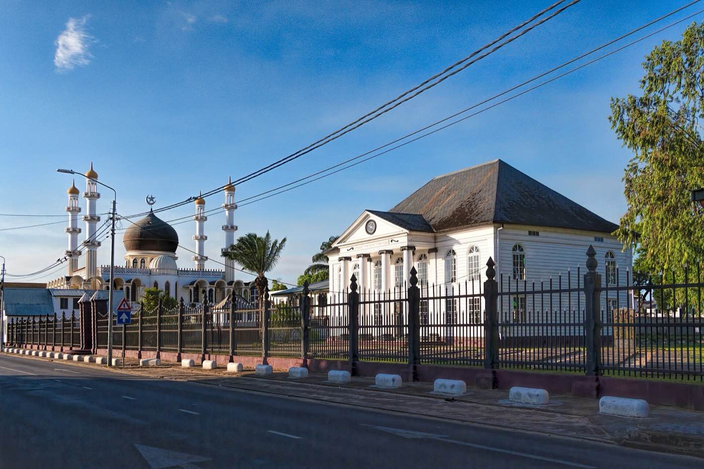 The white timber Neveh Shalom synagogue on Keizerstraat, with the minarets and dome of the mosque next door.